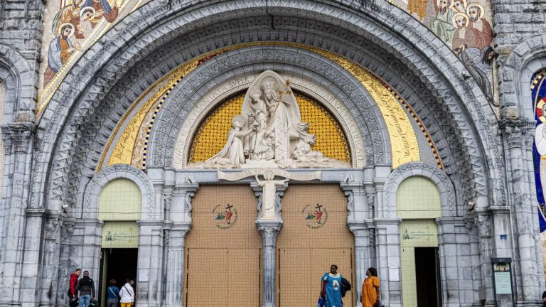 The grand entrance of Lourdes Basilica, featuring stunning religious art and architecture.