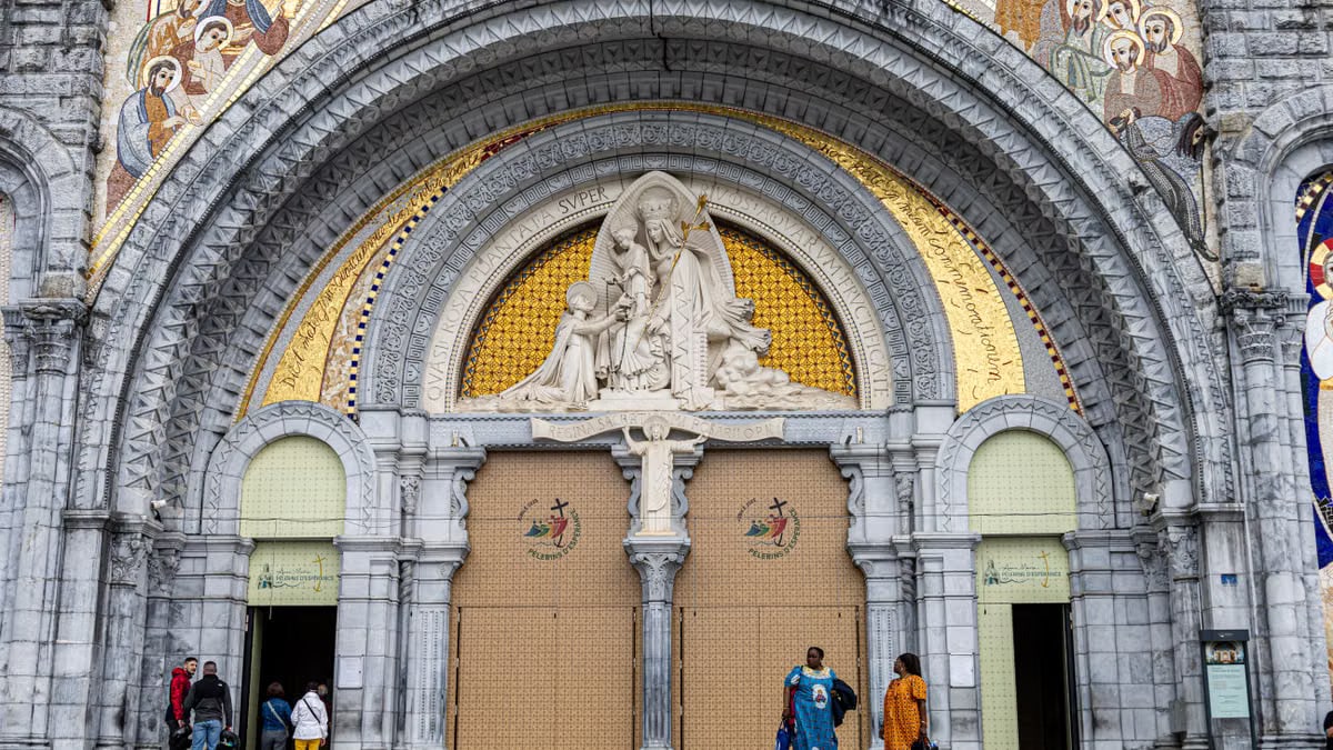 The grand entrance of Lourdes Basilica, featuring stunning religious art and architecture.